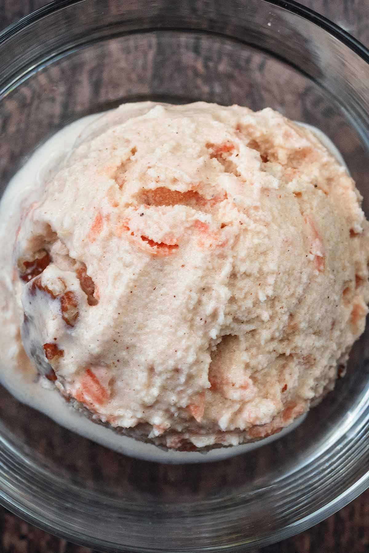A ball of carrot cake ice cream in a serving glass.