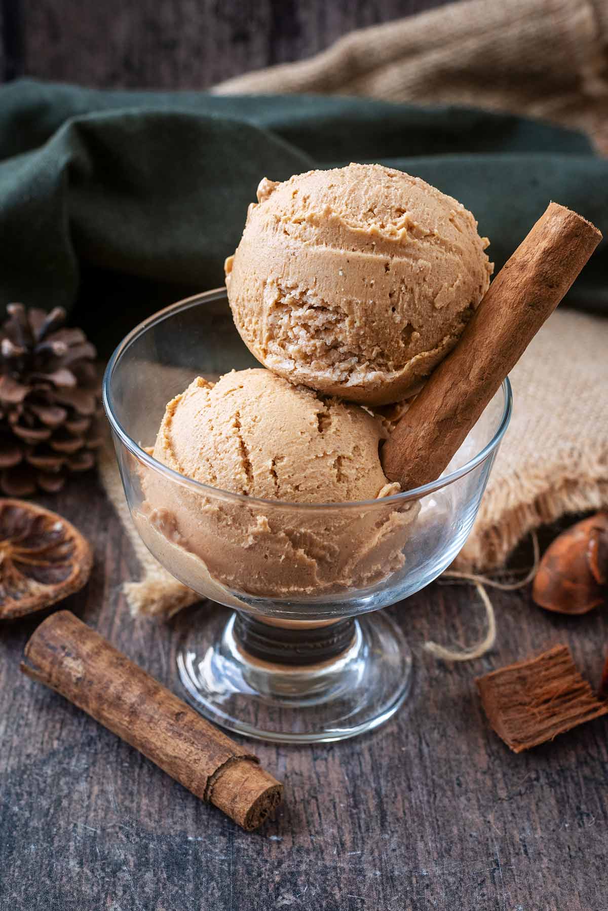 Two balls of pumpkin ice cream in a serving glass.