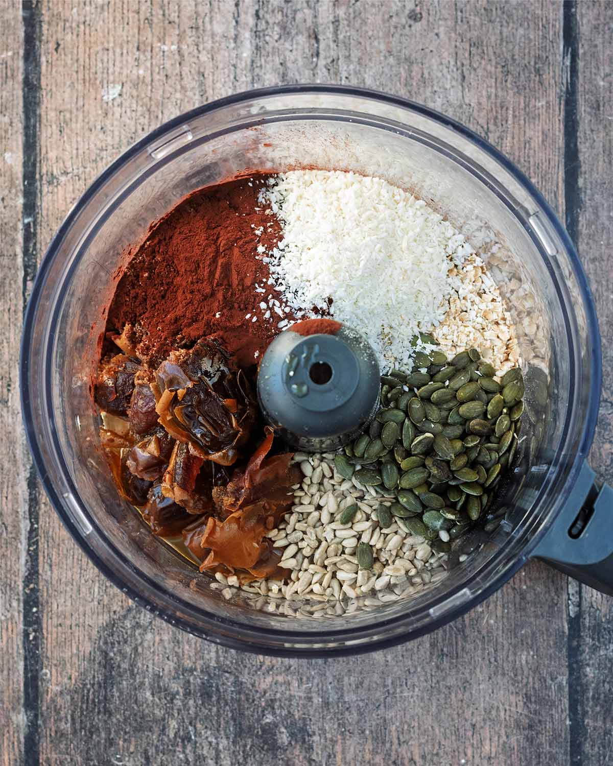 Seeds, coconut, dates, oats and cocoa powder in a food processor.
