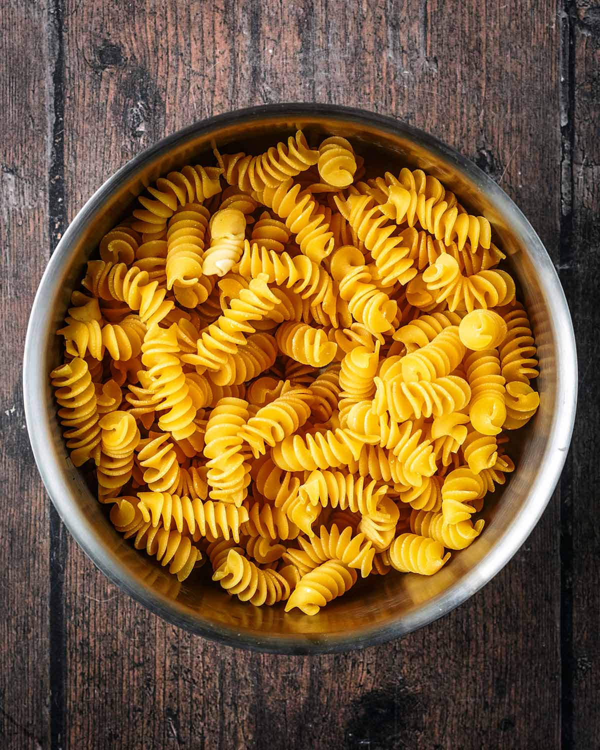 Fresh fusilli pasta in a saucepan.