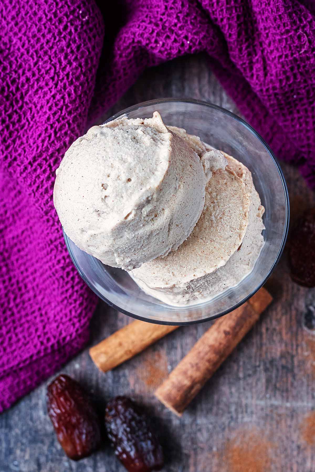 Two balls of ice cream in a serving glass as viewed from above.