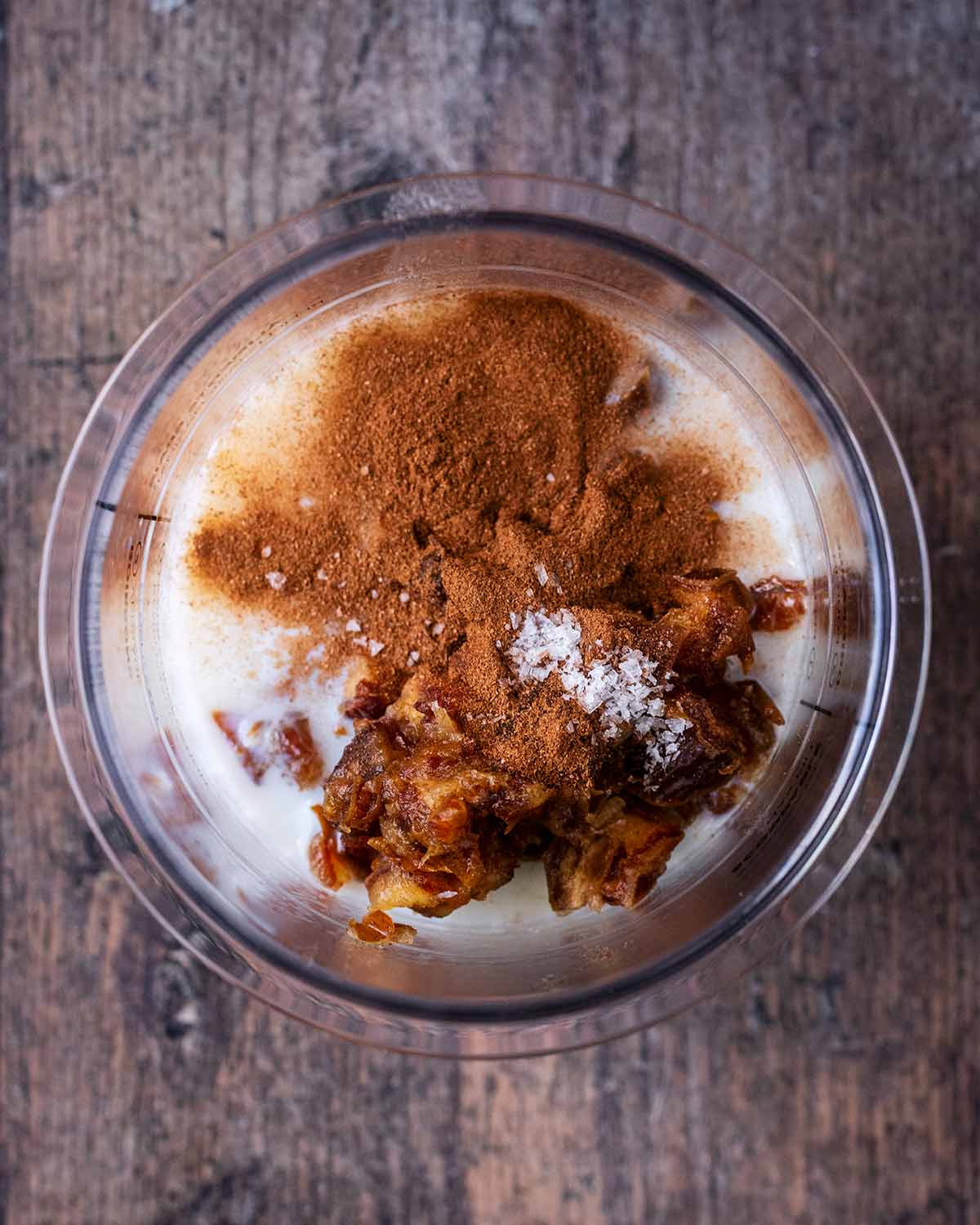 Yogurt, milk, soaked dates and spices in a Ninja Creami pint tub.