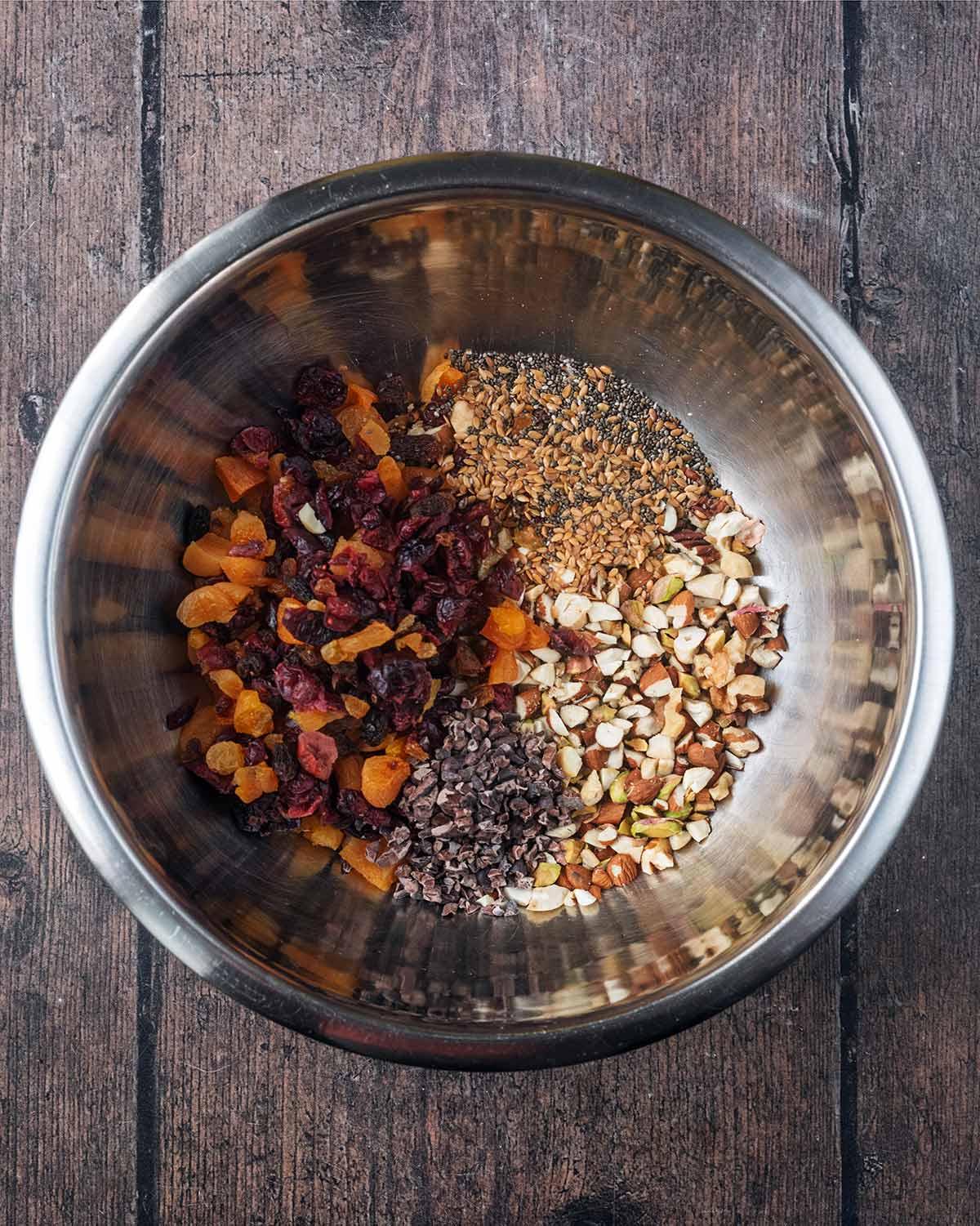 Nuts, seeds and dried fruit in a mixing bowl.