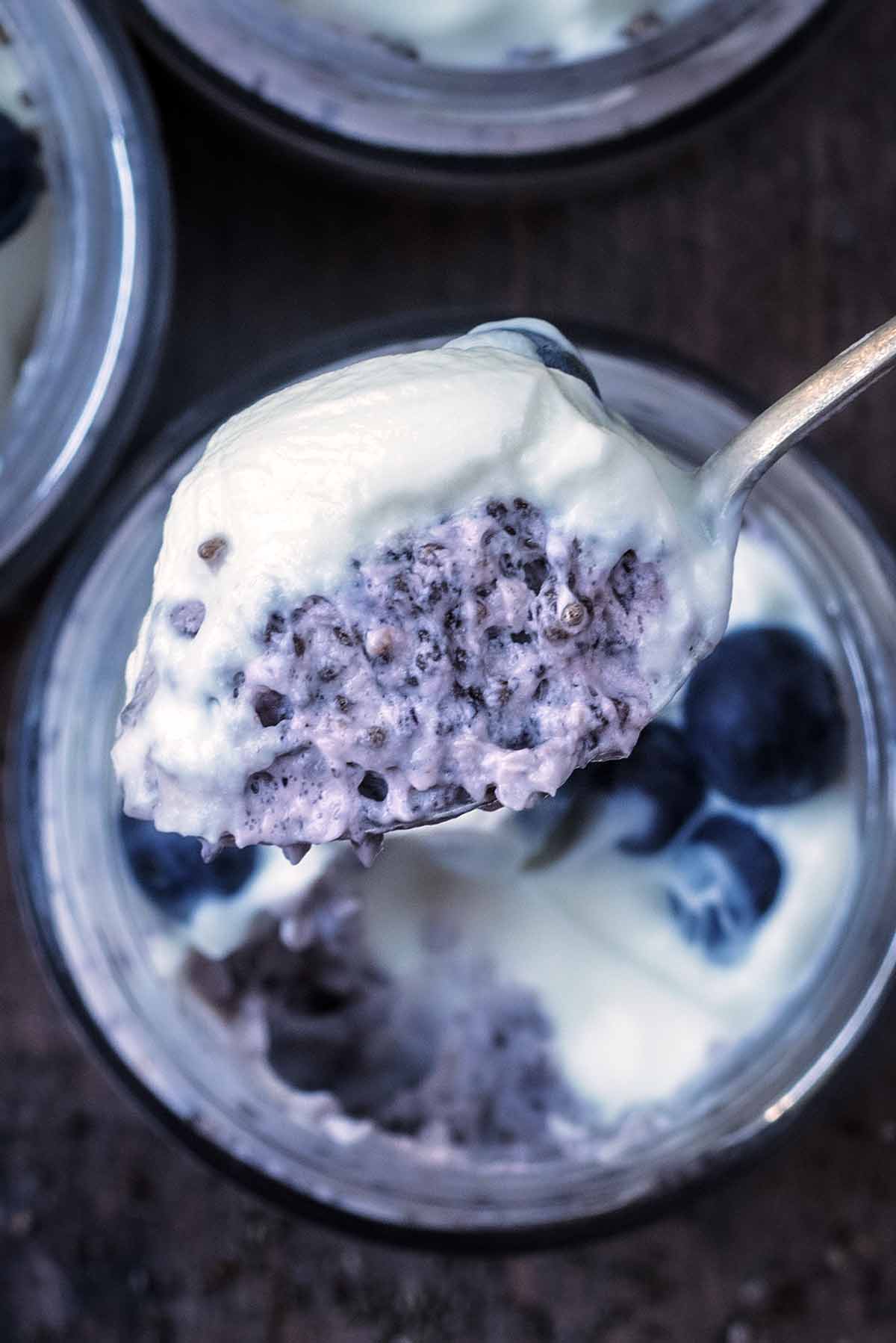 A spoonful of chia pudding being lifted out of a jar.