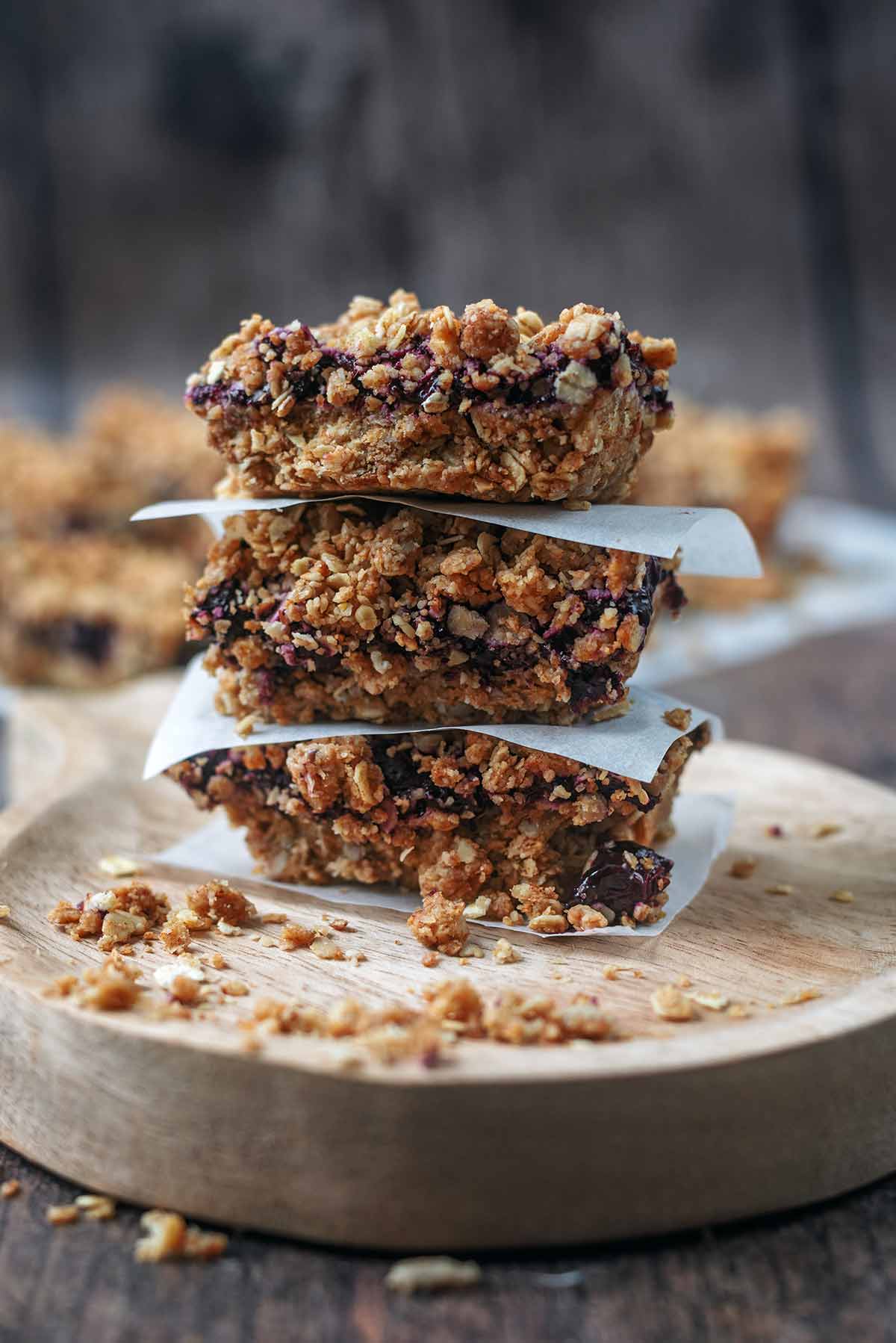 Three oatmeal bars stacked up with baking paper between them.