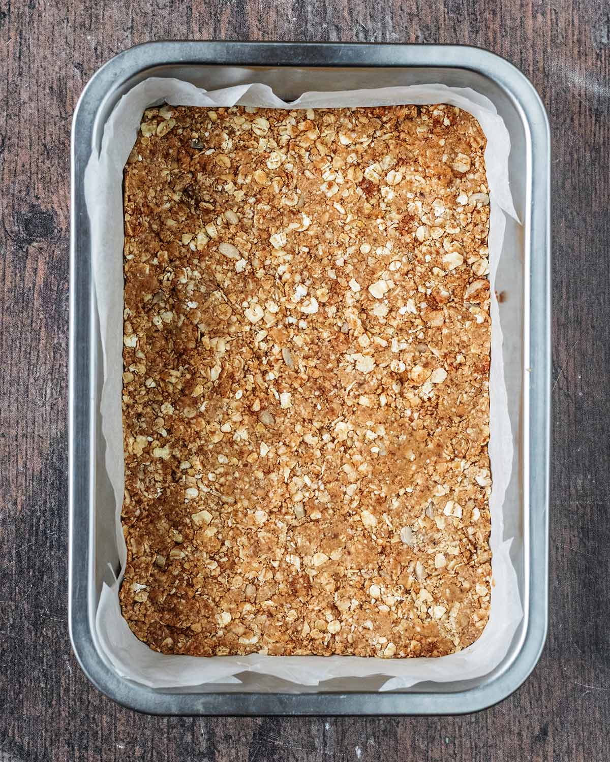The oat mixture pressed into a lined baking tin.