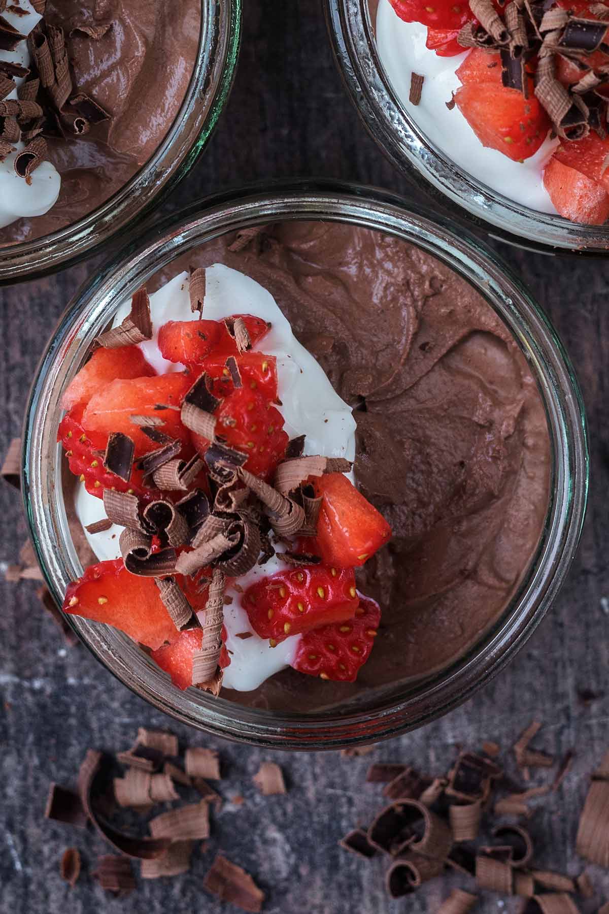 Chocolate mousse topped with a dollop of Greek yogurt, chopped strawberries and chocolate curles.