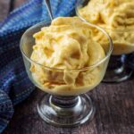A serving glass full of mango frozen yogurt.