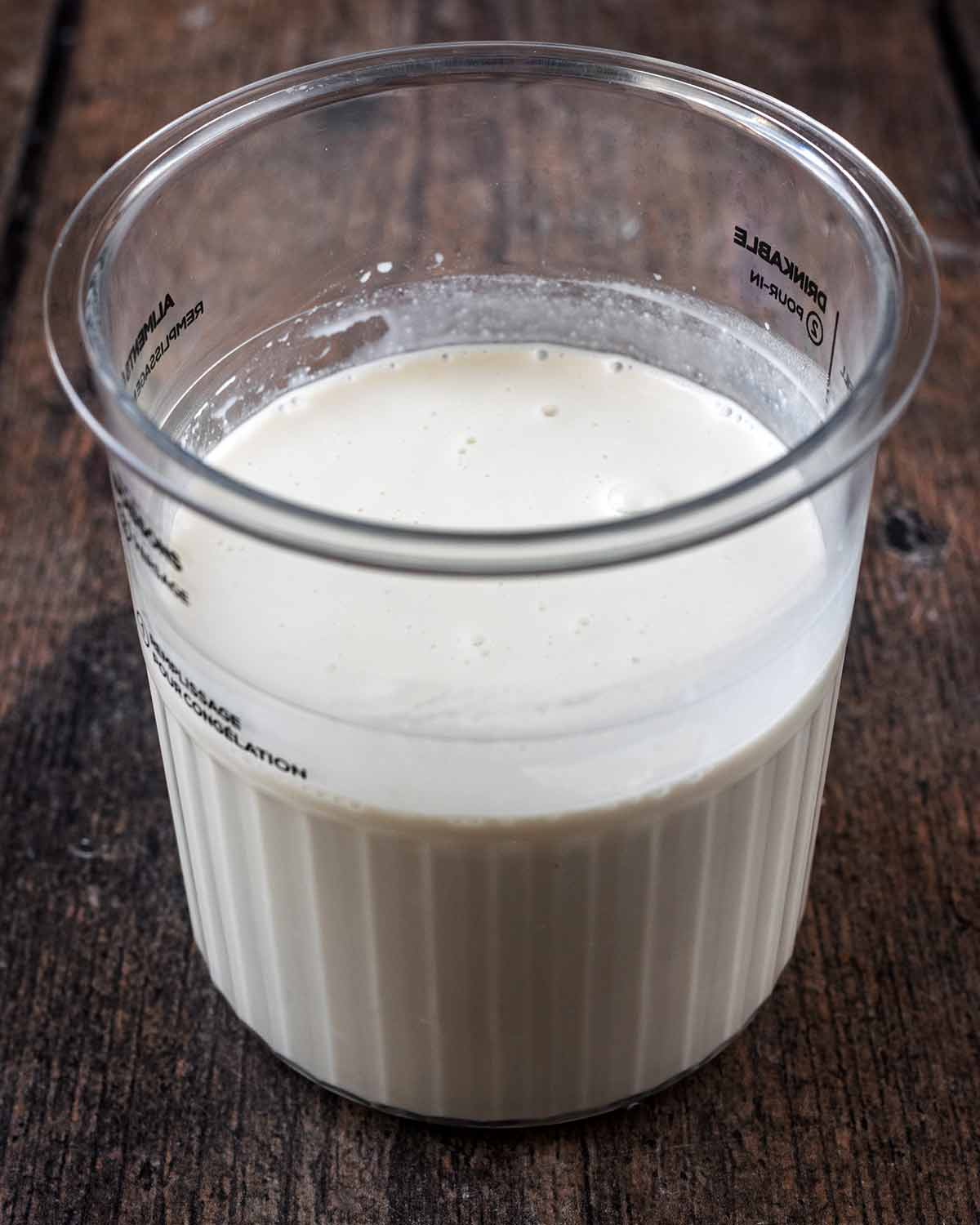 A ninja creami tub containing coconut milk and yogurt.