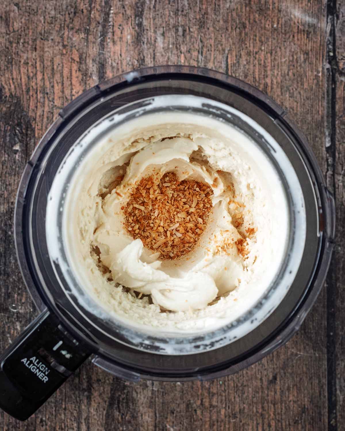 Dessicated coconut added to a well made in the coconut ice cream.