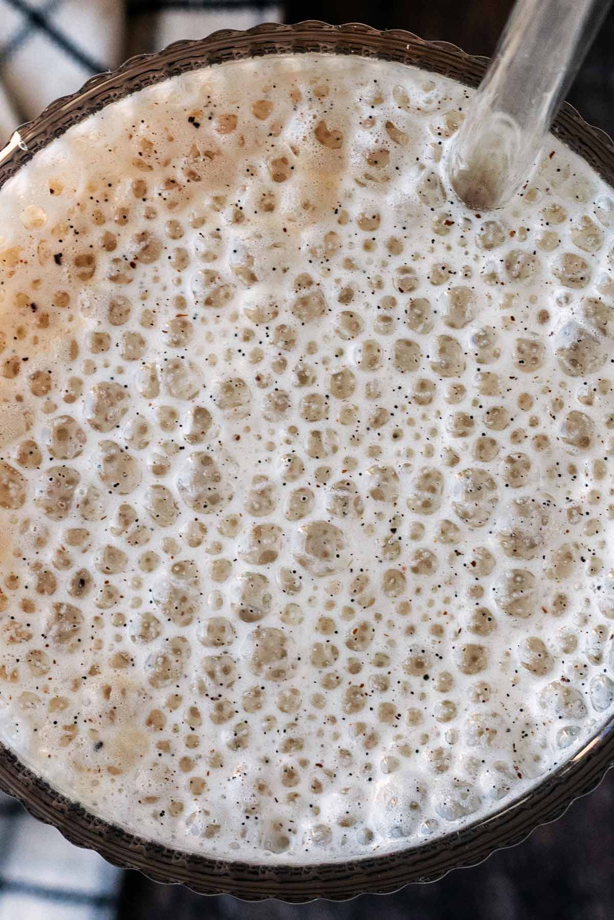 Cold foam bubbles on top of a glass of drink.
