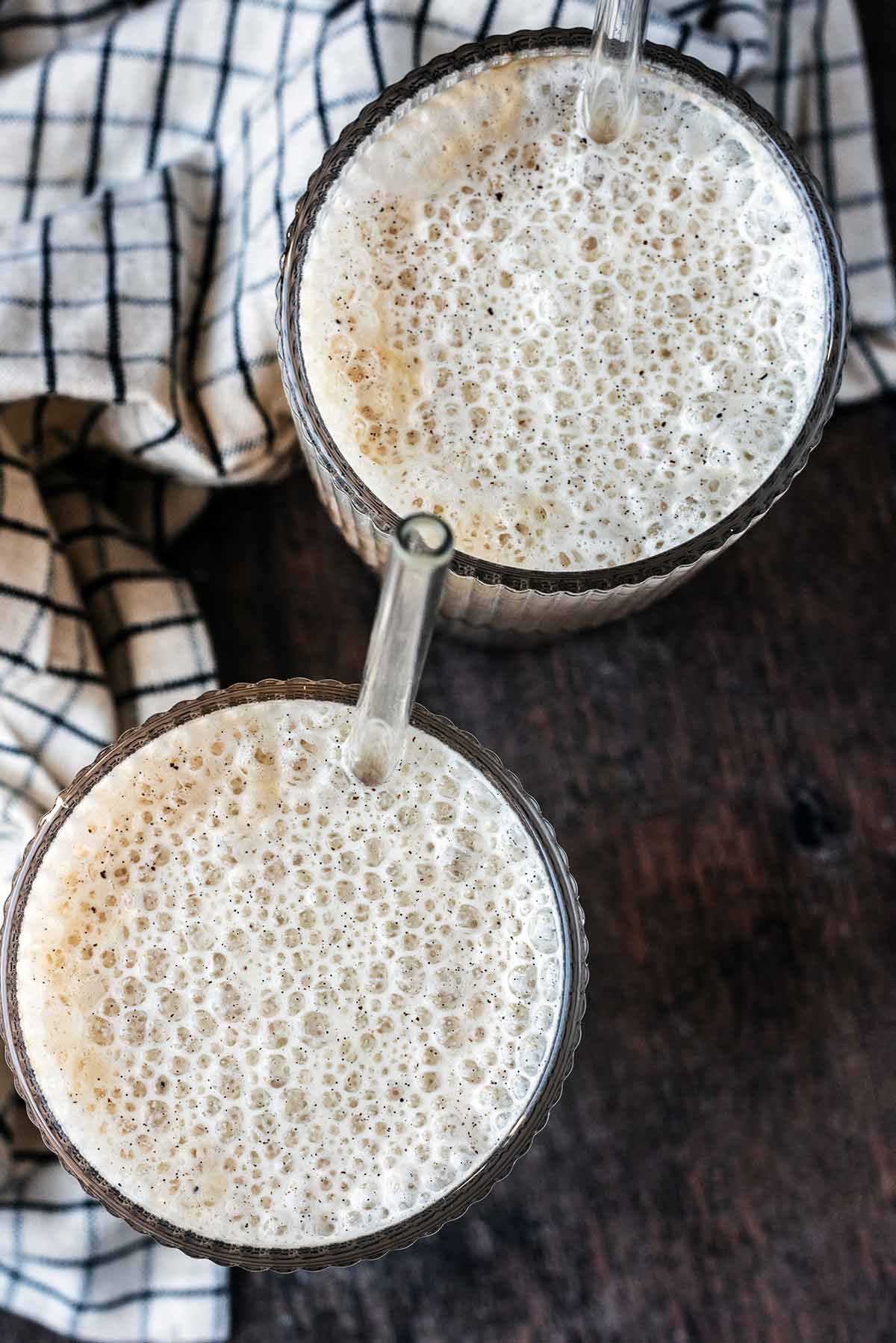 Two glasses of drink topped with a cold foam as viewed from above.