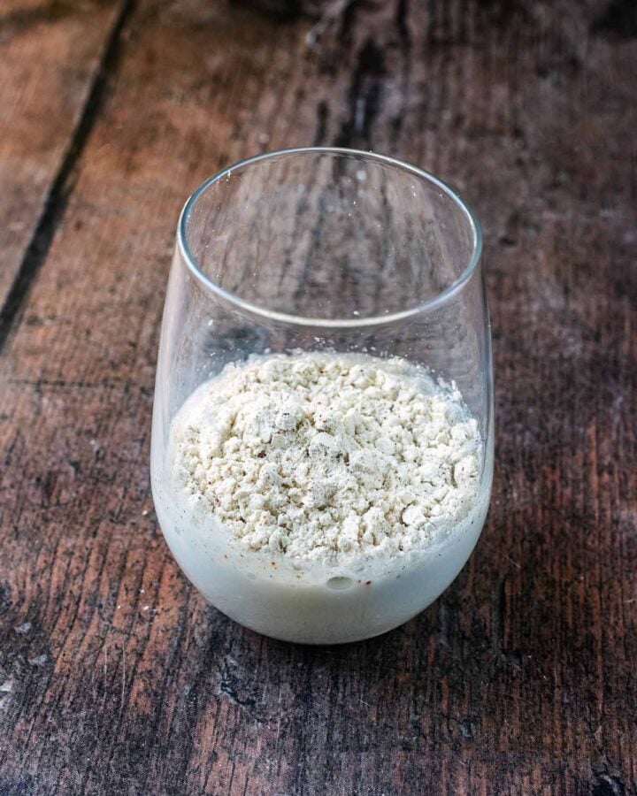 A glass containing milk and protein powder.