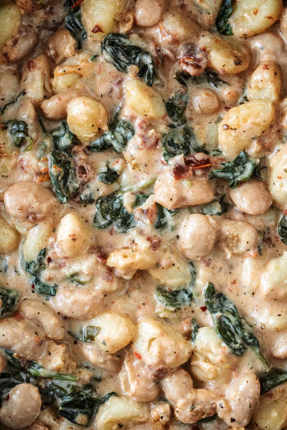 Gnocchi, beans, spinach and tomatoes in a creamy sauce.
