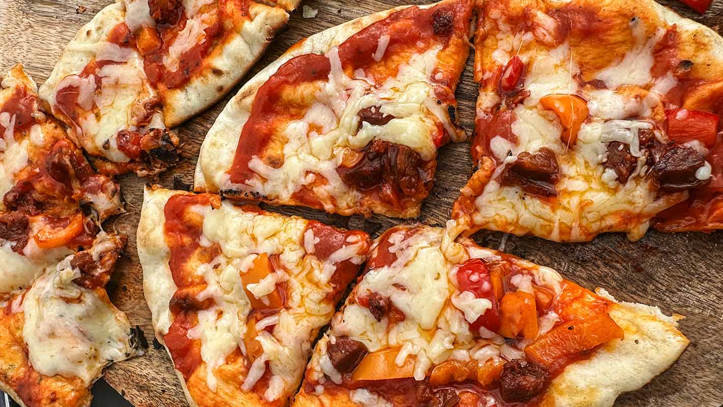 A flatbread pizza cut into four slices.