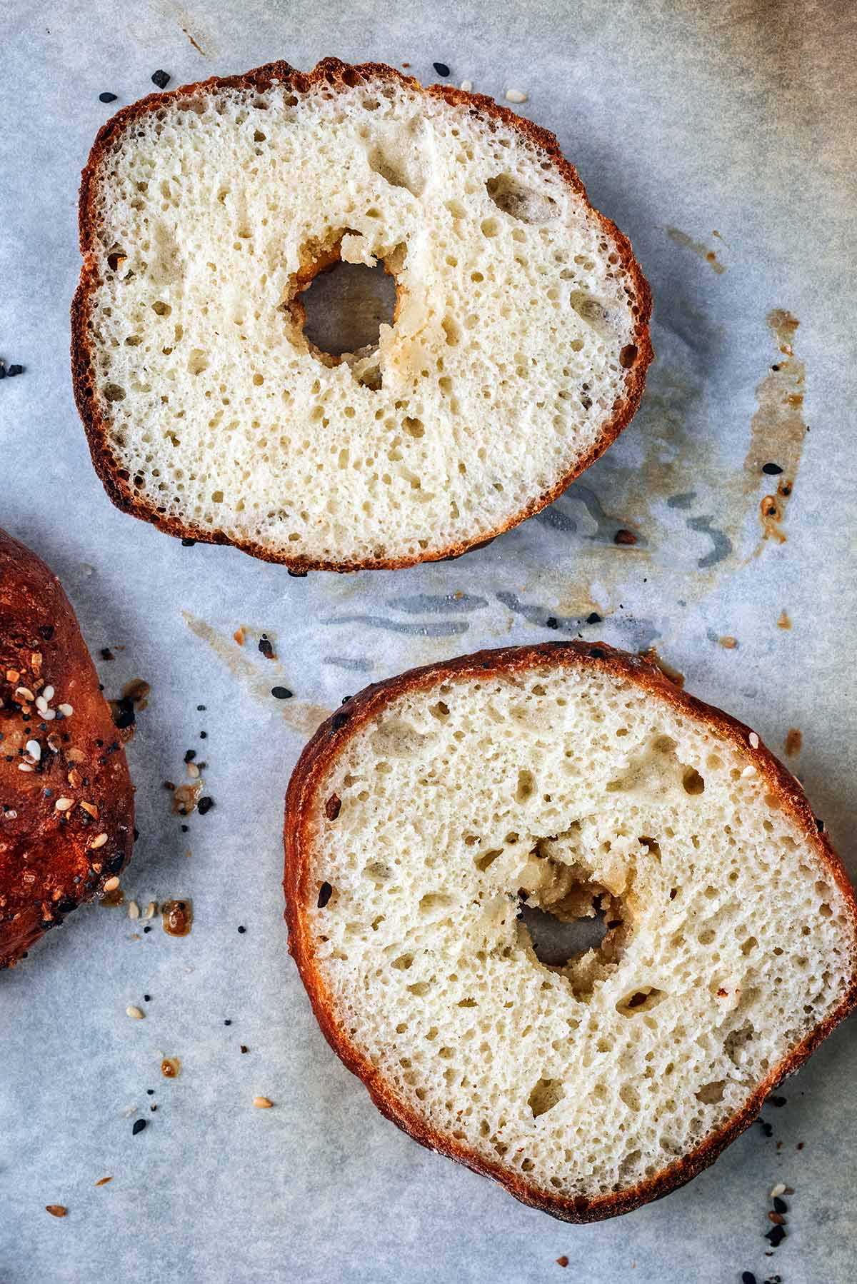 A bagel that has been sliced in half showing the fluffy inside texture.