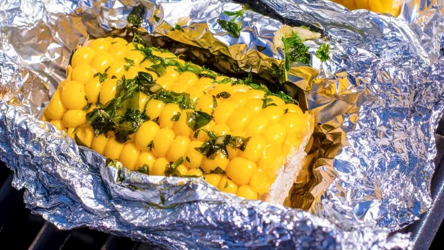 An ear of corn cooking in foil.