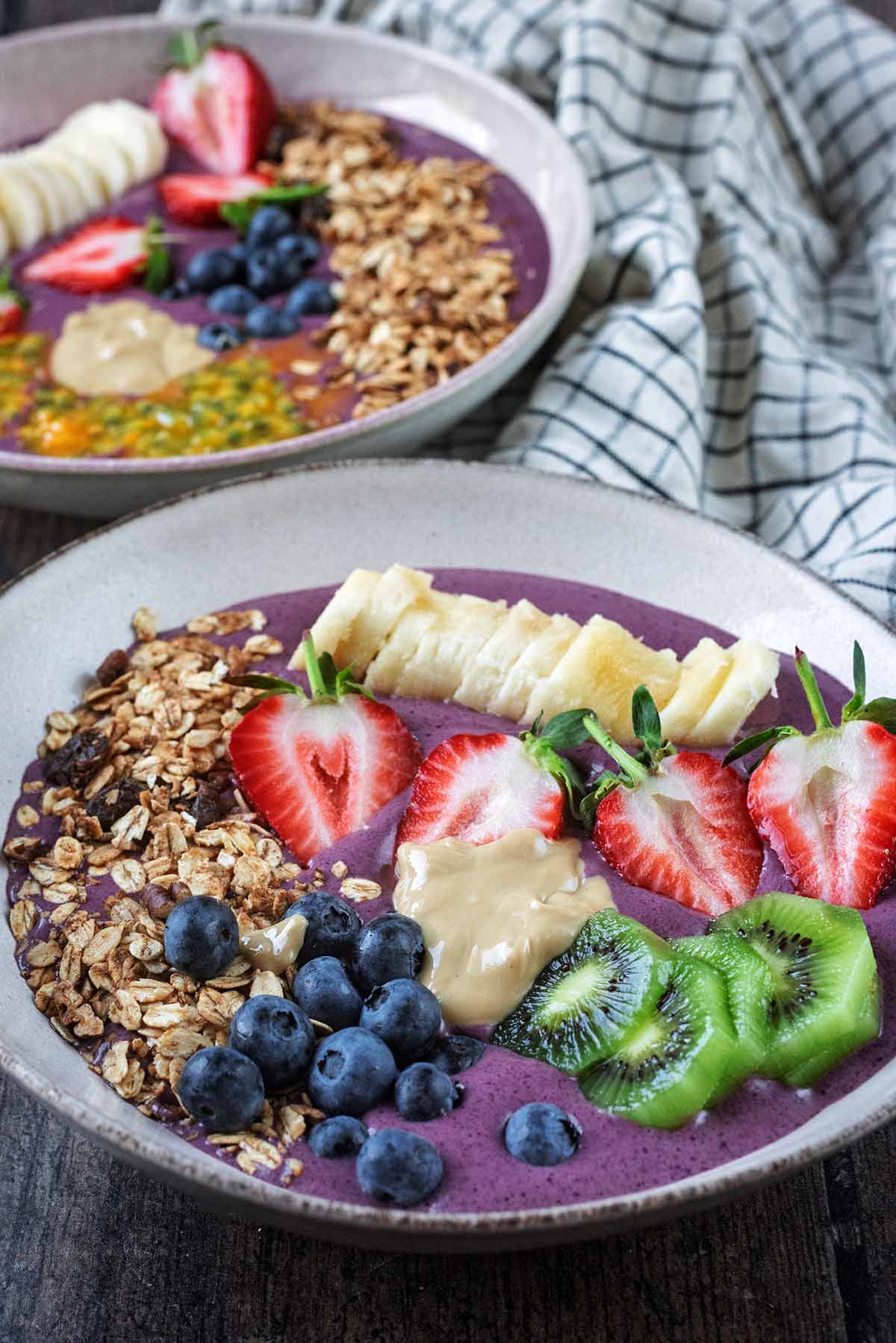 A fruit topped acai bowl with abother in the background.