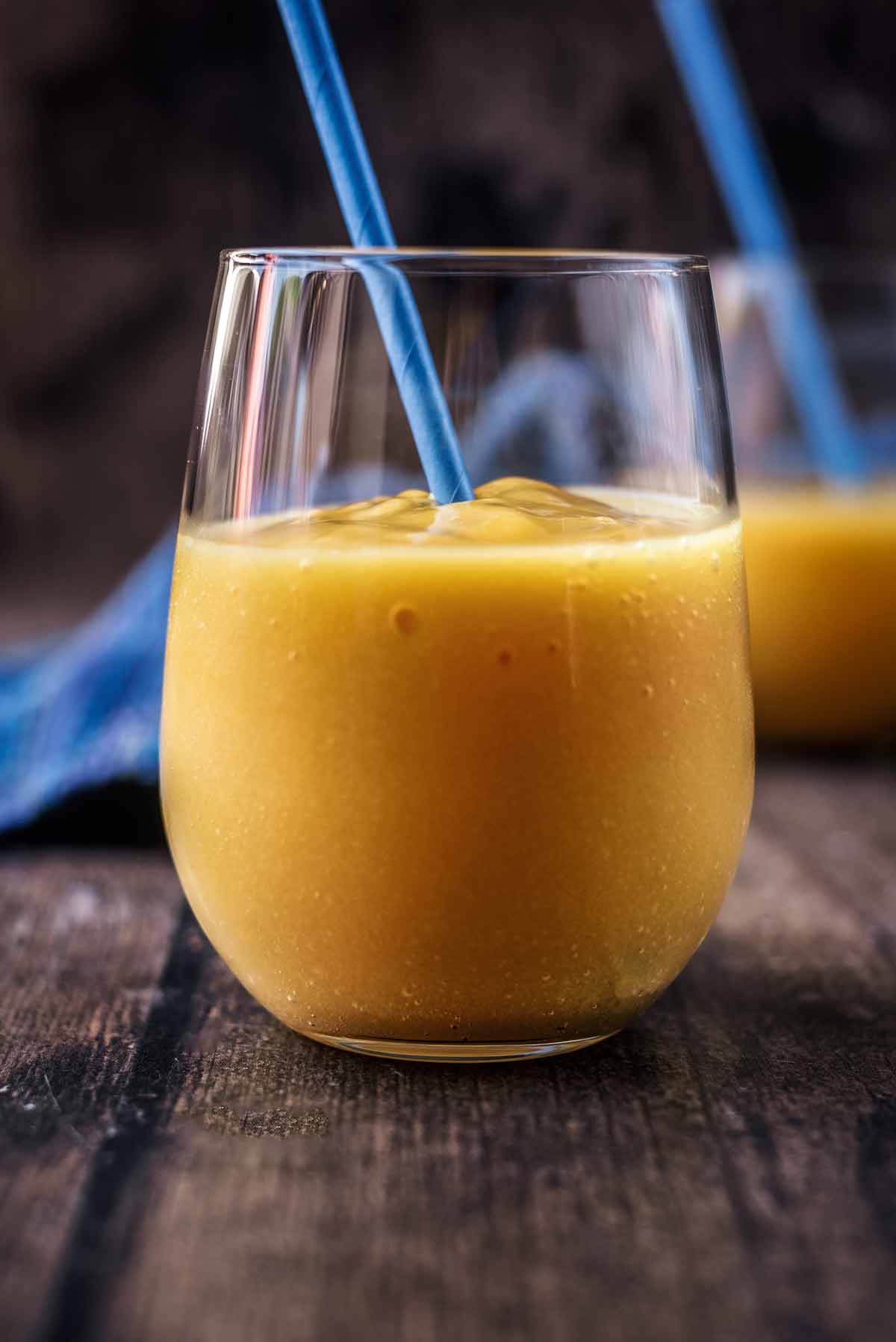 A glass of a deep yellow coloured drink.