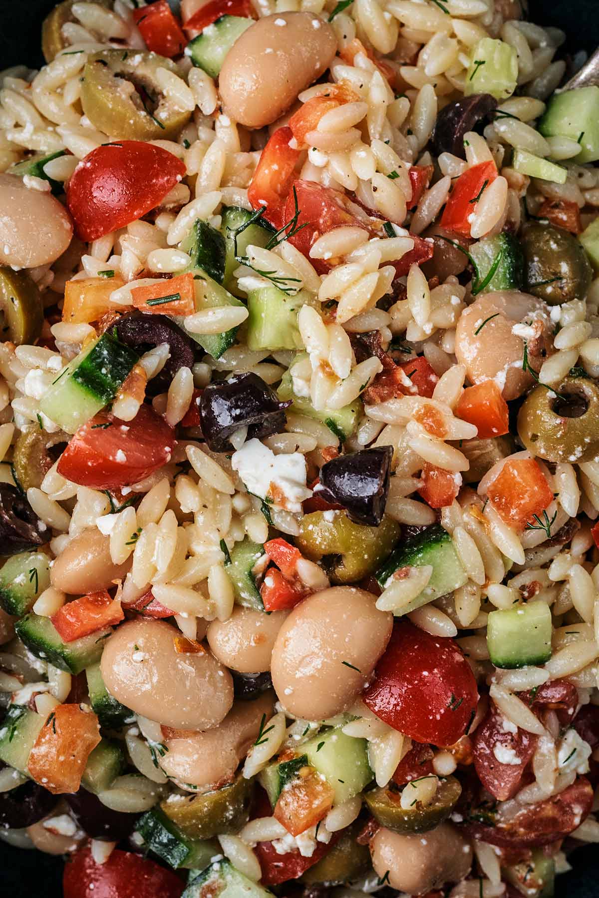 Cooked orzo, white beans and chopped salad vegetables.