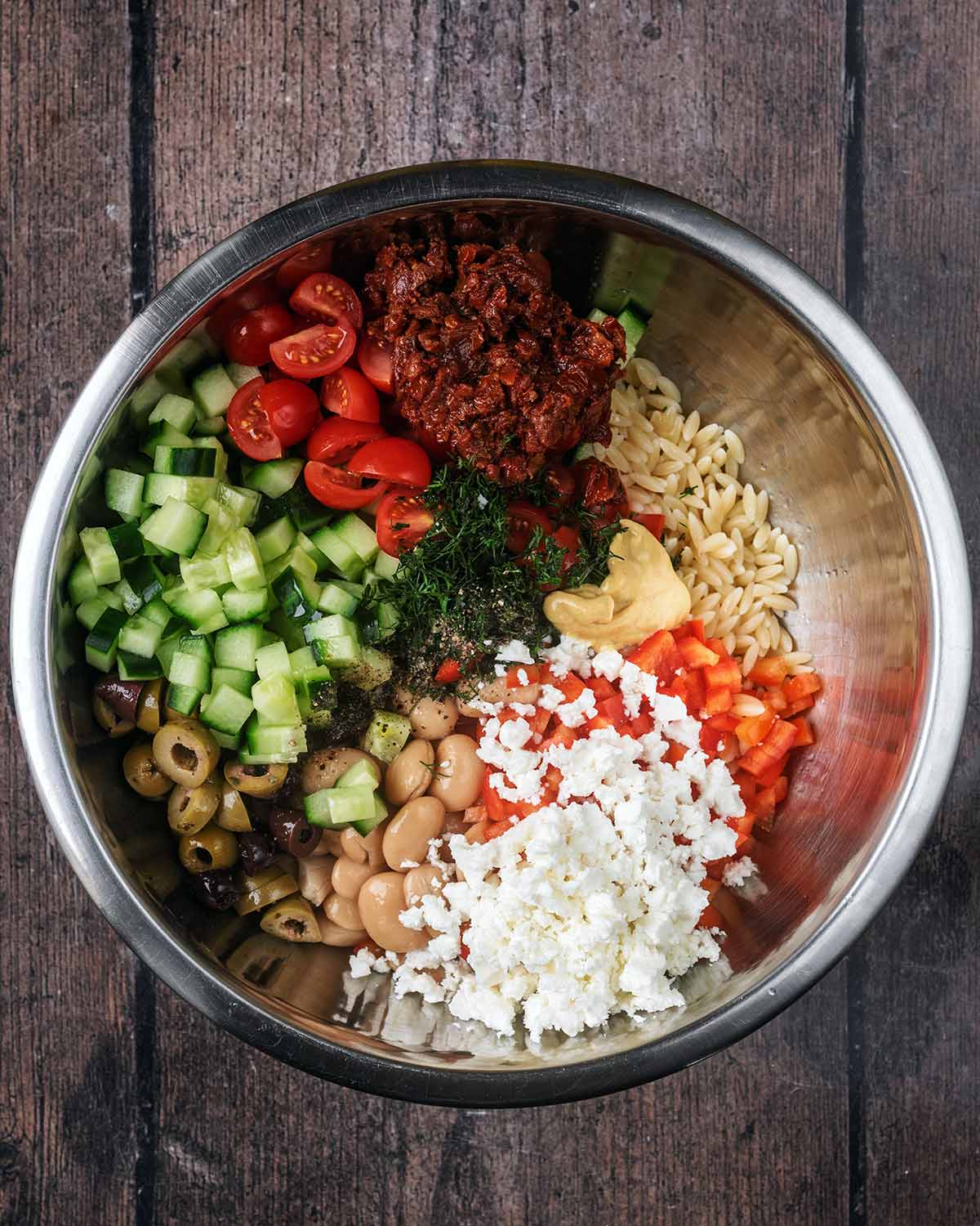 Chopped salad vegetables, beans, crumbled feta and chopped dill added to the bowl.