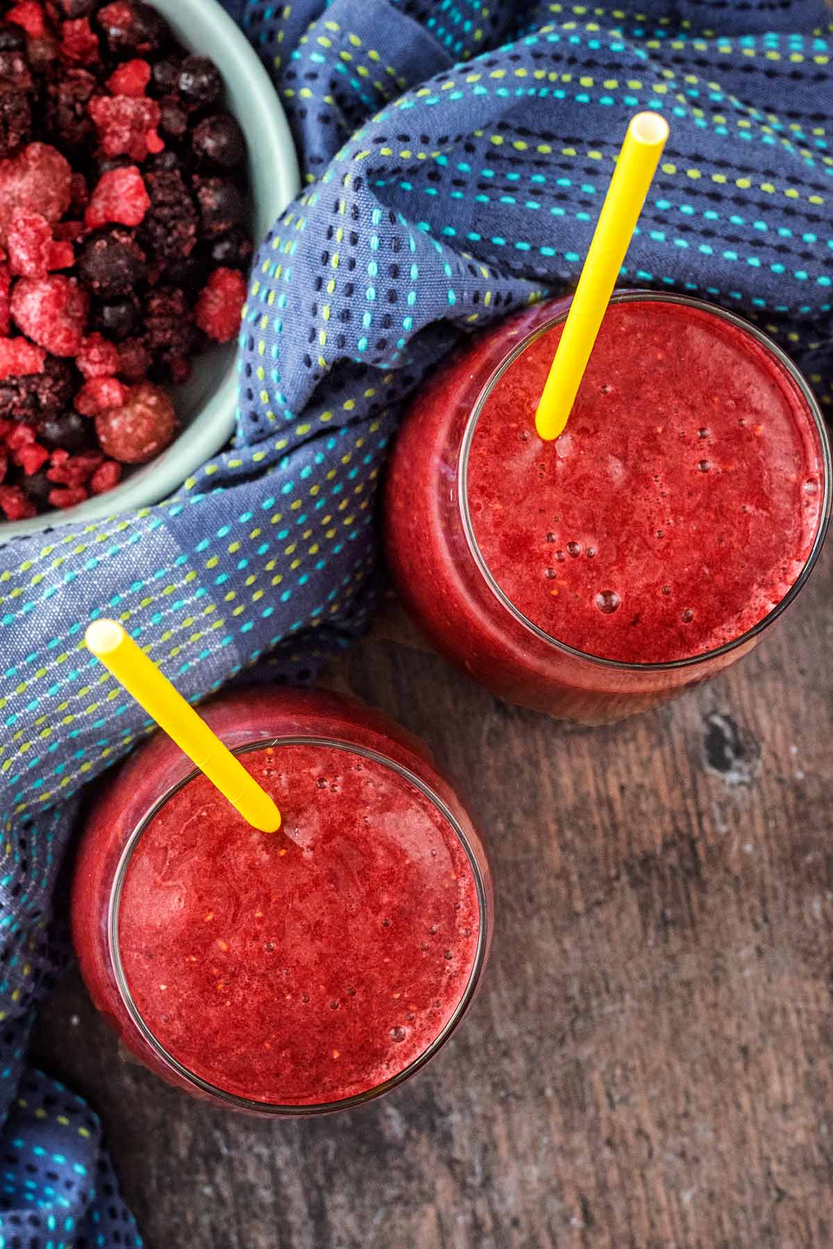 Two glasses of red slushie style drink as viewed from above.