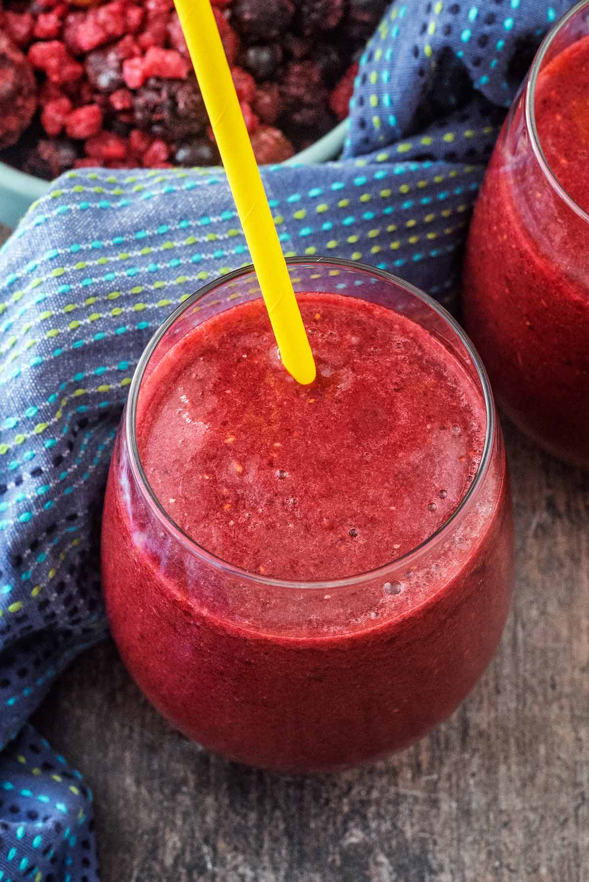 A glass of berry cooler in front of a blue towel.