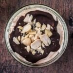 Snickers Greek yogurt pot on a wooden surface.