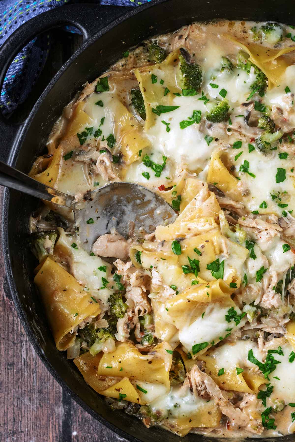 A serving spoon in a pan od lasagna.