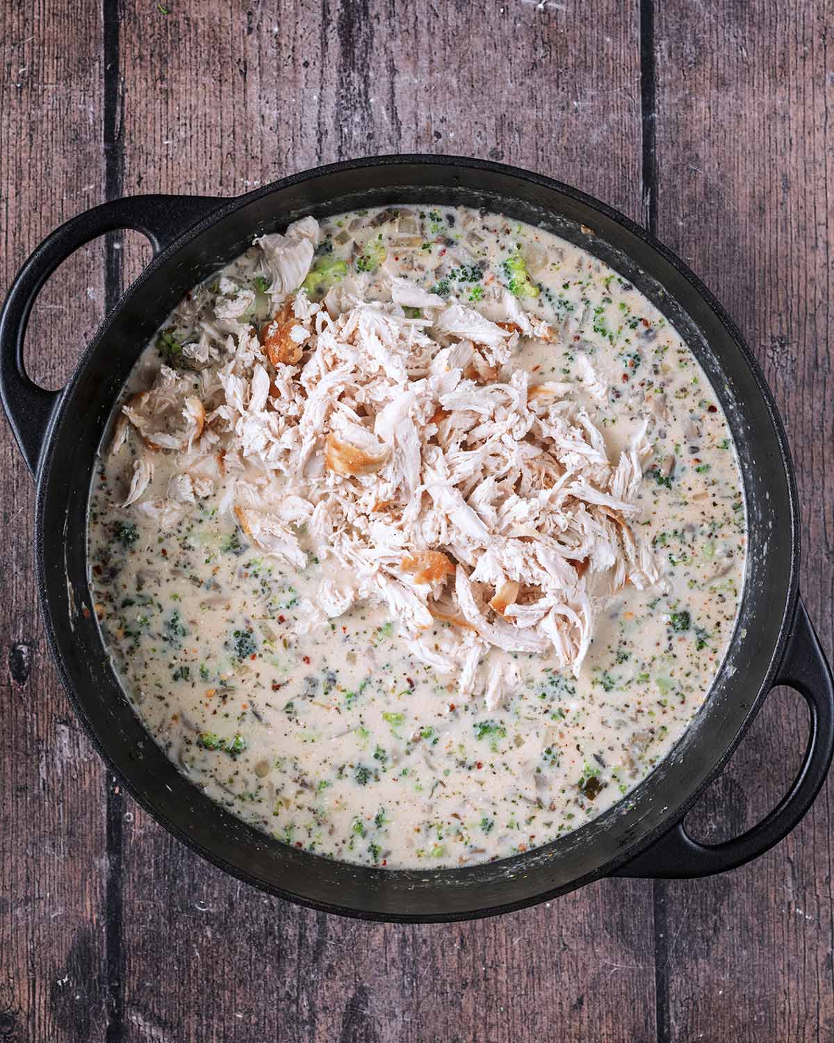 A creamy sauce now in the pan with shredded cooked chicken added.