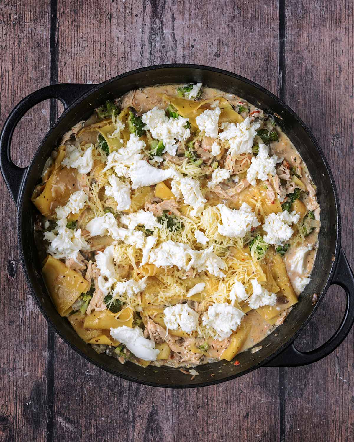 Grated cheddar and torn mozzarella added to the pan.