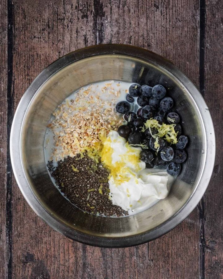 Oats, yogurt, blueberries, chia seeds and lemon zest in a mixing bowl.