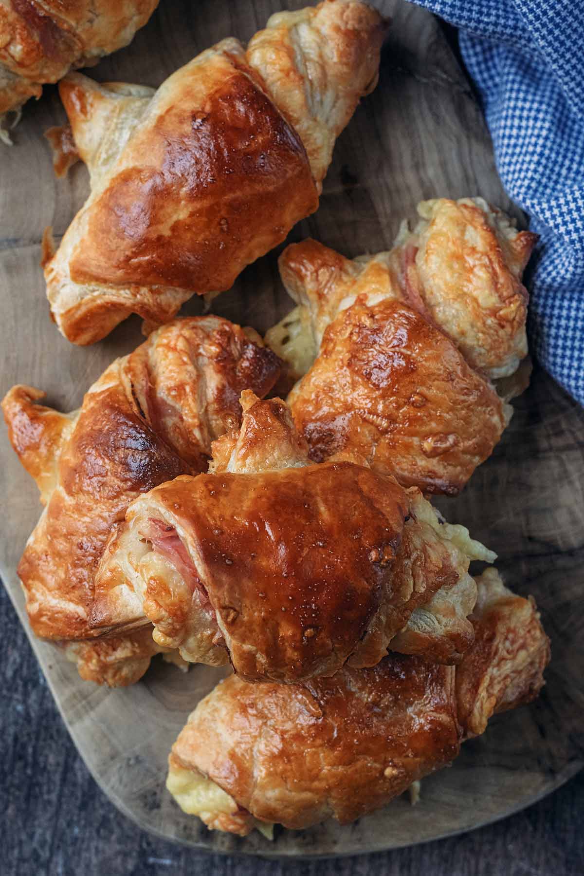 Mini croissants on a wooden serving board.