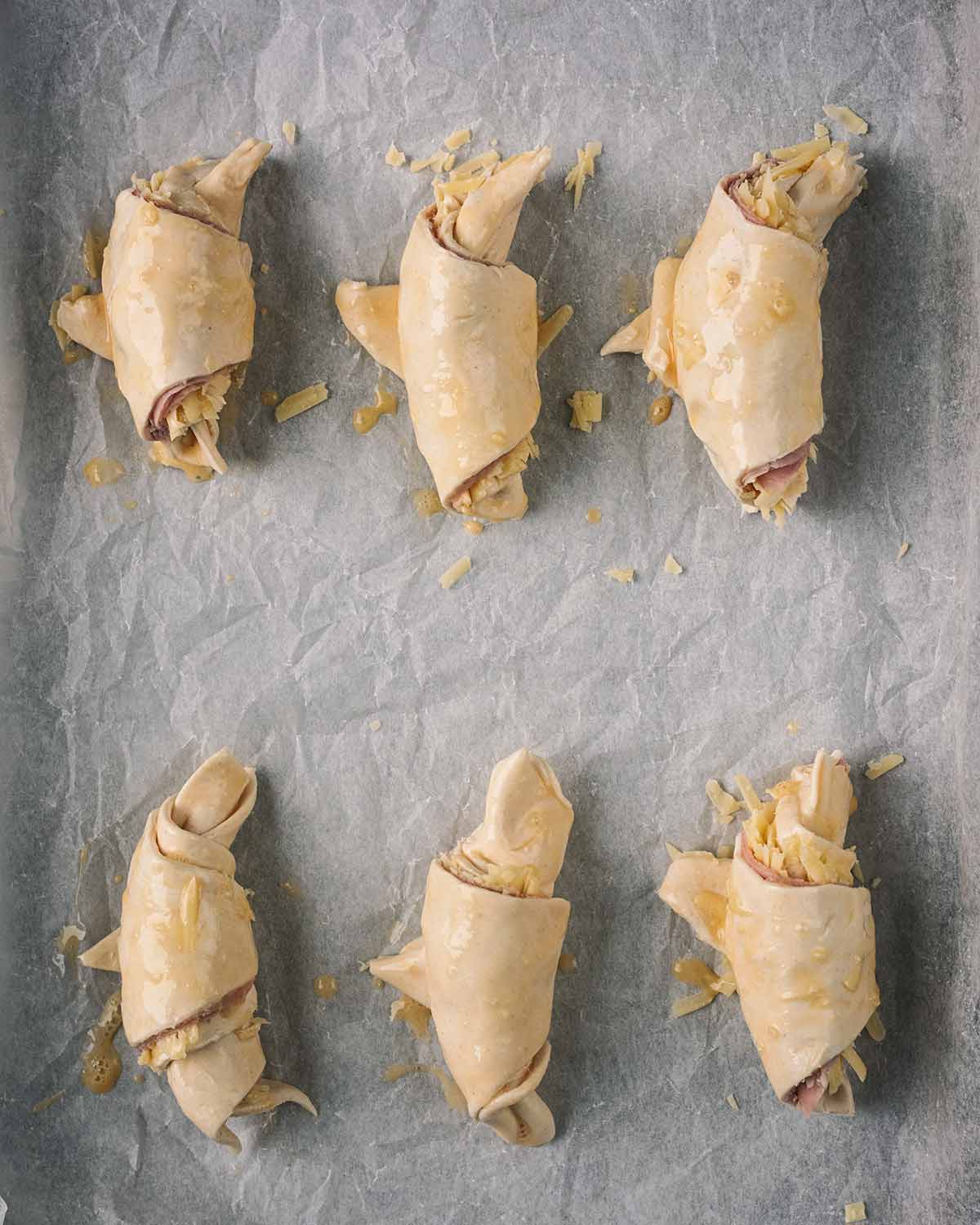 Egg wash applied to the uncooked croissants.