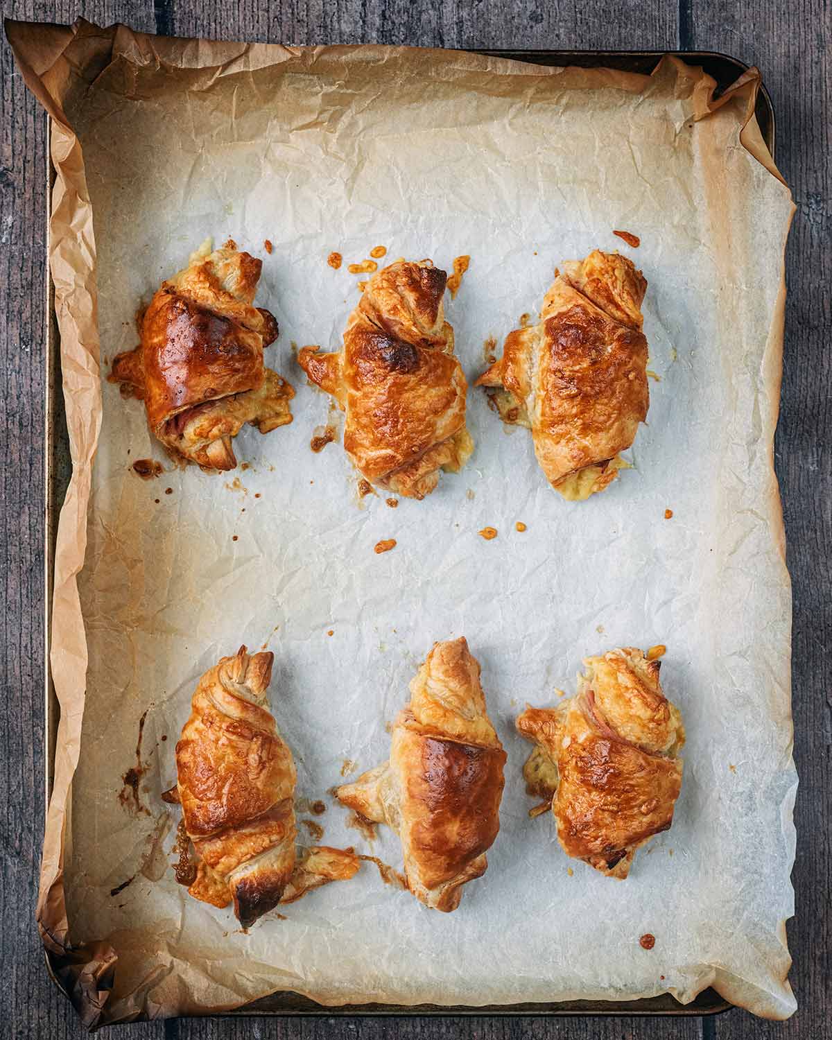 Six cooked mini croissants on the baking tray.