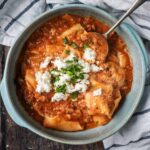 A bowl of slow cooker lasagna soup with a spoon in it.