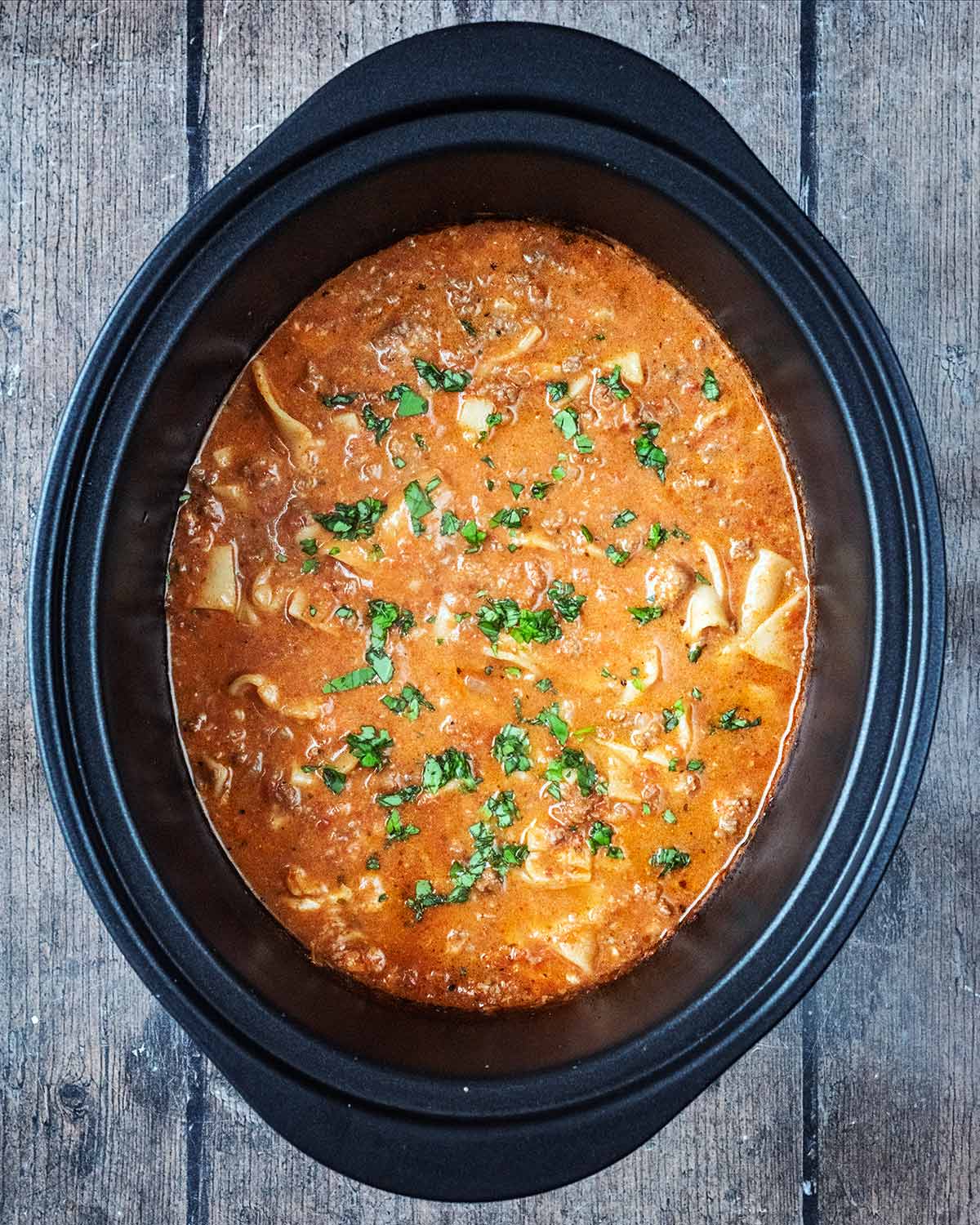 Chopped basil added to the lasagna in the slow cooker.