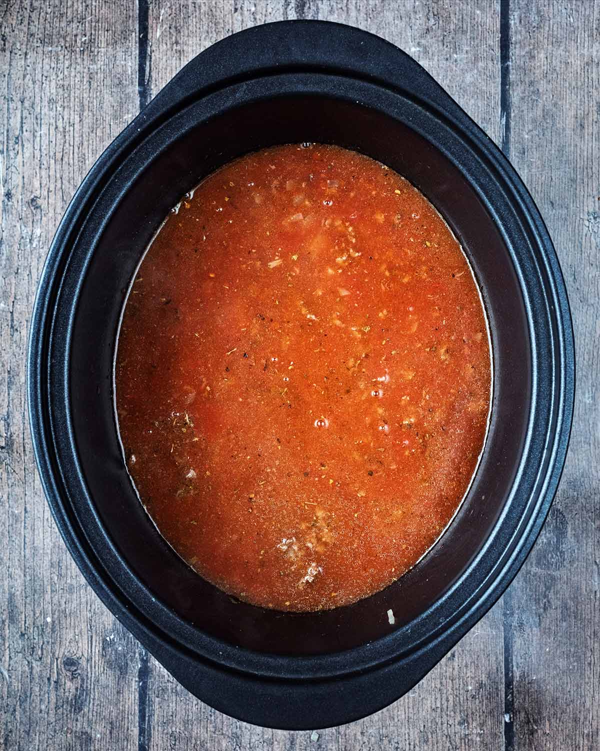 Tomatoes, pasta sauce and stock added to the slow cooker.