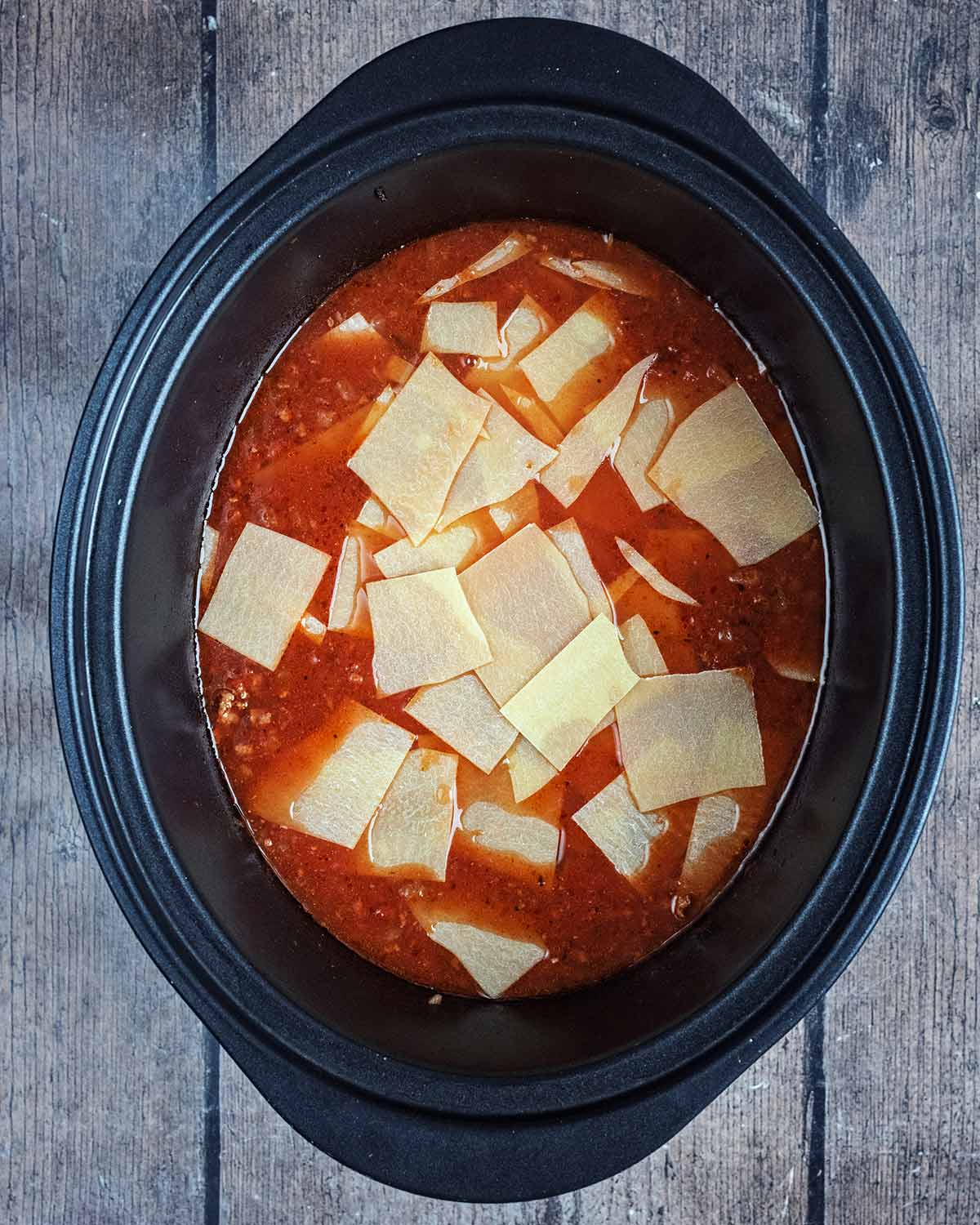 Dry, broken lasagna sheets added to the lasagna sauce.