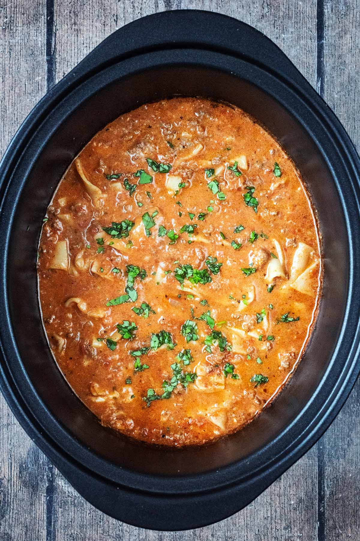 A slow cooker bowl containing slow cooker lasagna soup.